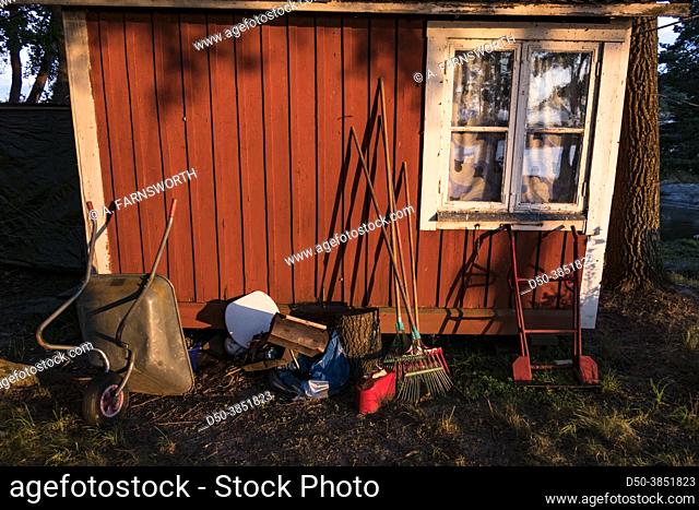 Stockholm, Sweden July 23, 2021 Garden tools outside a shed at sunset
