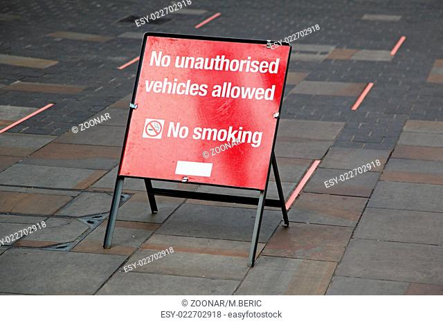 Red warning board no smoking and cars