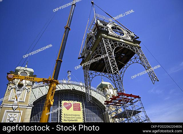 Workers with the help of cranes bring down the clock tower from the roof of the reconstructed Industrial Palace at the Prague Exhibition Grounds, on June 22