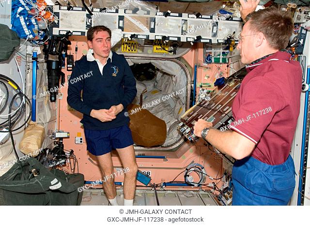 Inside the International Space Station's Node 1 or Unity, NASA astronaut Chris Ferguson (right), STS-135 commander, talks with Russian cosmonaut Sergei Volkov