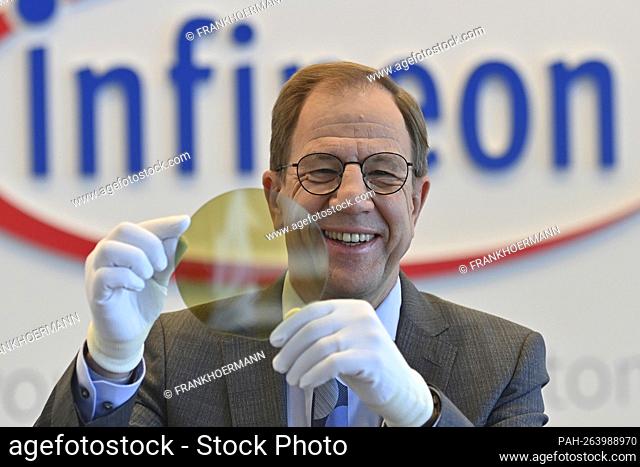 Dr. Reinhard Ploss Chairman of the Management (CEO) in front of the logo, holding a transparent wafer (semiconductor), emblem, lettering, single image