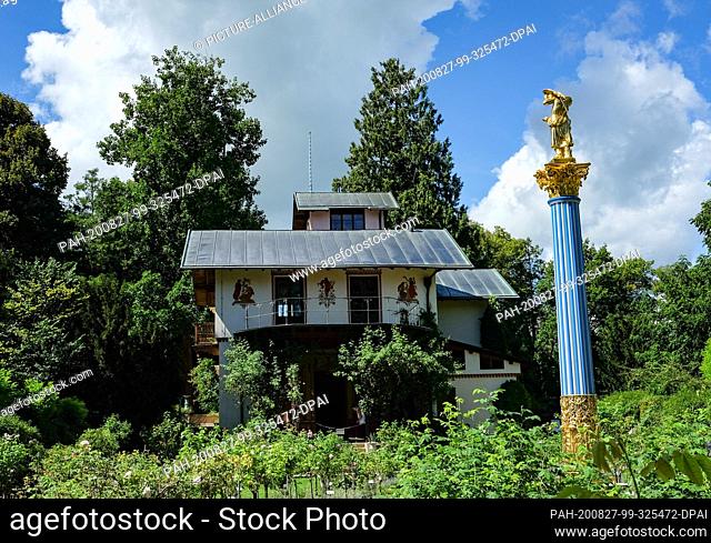 19 August 2020, Bavaria, Feldafing: The island villa, the so-called casino, and the white-blue glass column with the sculpture of a girl with parrot on the Rose...