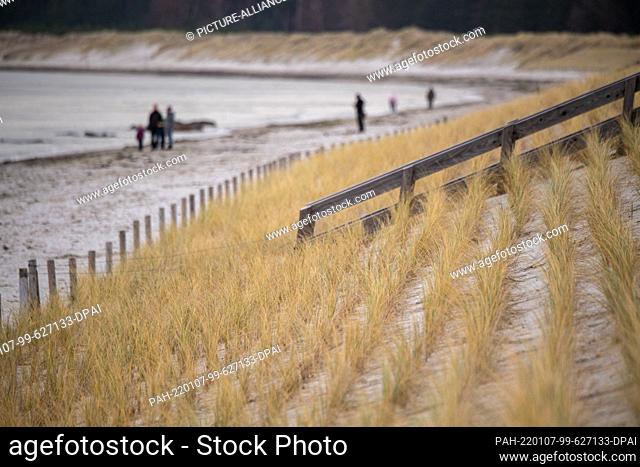 07 January 2022, Mecklenburg-Western Pomerania, Lubmin: Walkers are out and about on the Baltic Sea beach in the seaside resort of Lubmin