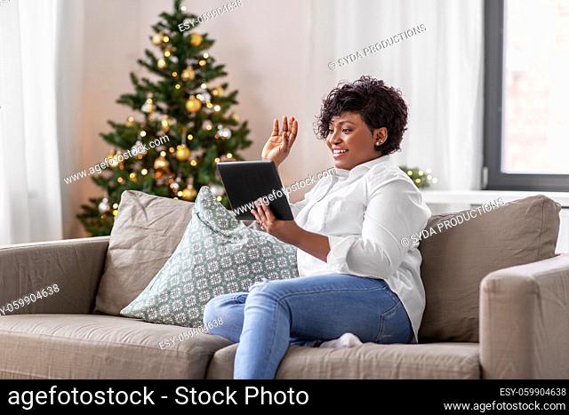 african woman with tablet pc at home on christmas