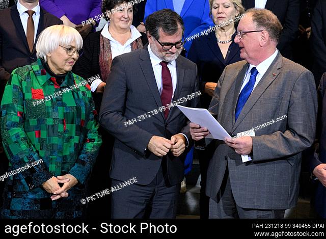 18 December 2023, Berlin: Wolfgang Schmidt (M, SPD), Head of the Federal Chancellery, receives 15 theses on ""Cohesion in Diversity"" from Claudia Roth (l