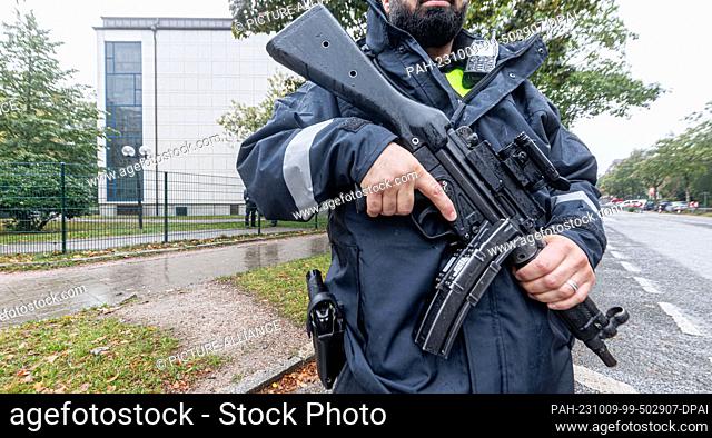 09 October 2023, Hamburg: A policeman with a submachine gun guards the Jewish synagogue in Hamburg with others after the Hamas attack on Israel