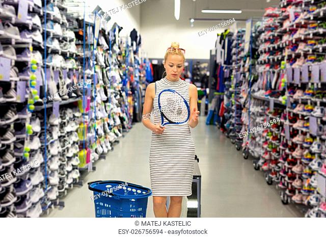 Beautiful caucasian woman shopping sports equipment in sportswear store