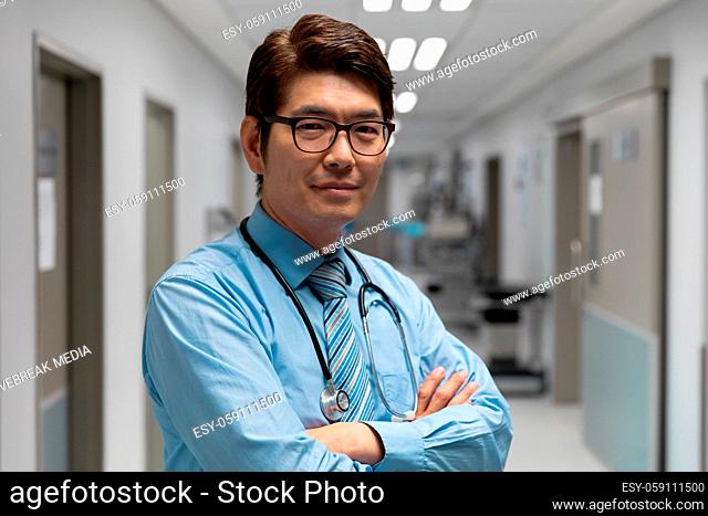 Portrait of mixed race male doctor standing in hospital corridor