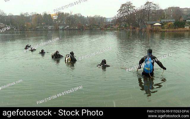 06 January 2021, Hamburg: Police divers search for a missing person in a pond in the Tonndorf district. Police divers searched several bodies of water for the...