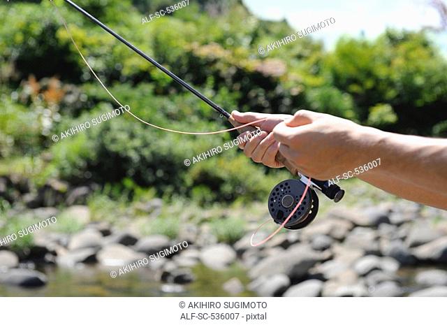 Hands holding fishing rod