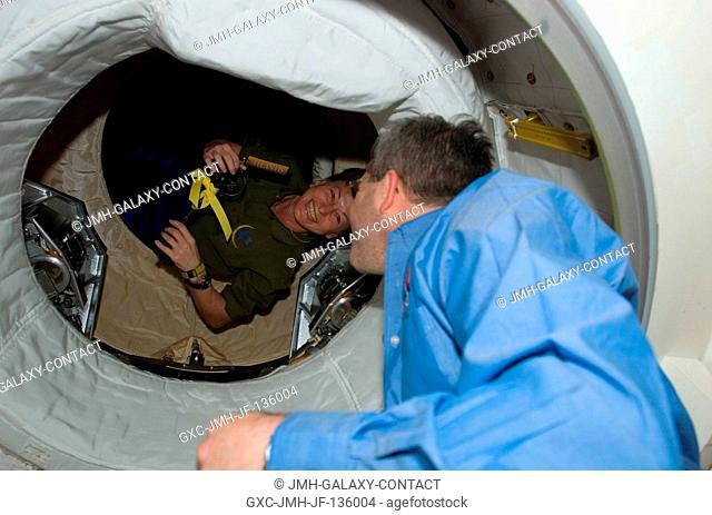 In a case of commander greets commander, astronauts Peggy Whitson of the International Space Station crew, and Steve Frick of the STS-122 Space Shuttle Atlantis...