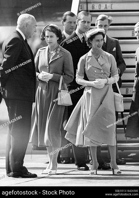 Smiling Princess - welcomed home at London airport. Princess Margaret, in pink and with a small hat, seen with The Queen, in blue