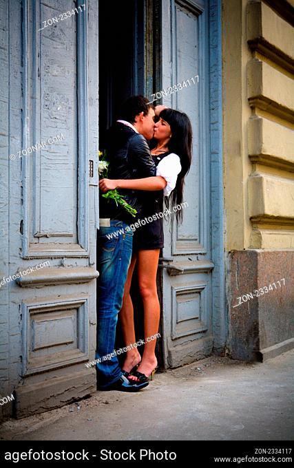 Happy young couple on city date kissing in the evening