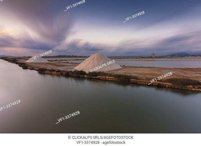 Salt pans with rows of tanks and two fully functional windmills on the coast connecting Marsala to Trapani, Trapani province, Sicily, Italy