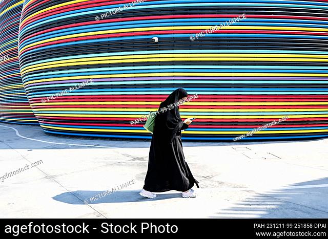 11 December 2023, United Arab Emirates, Dubai: A woman walks in front of the former Russian pavilion at EXPO 2020 on the grounds of the UN climate summit COP28
