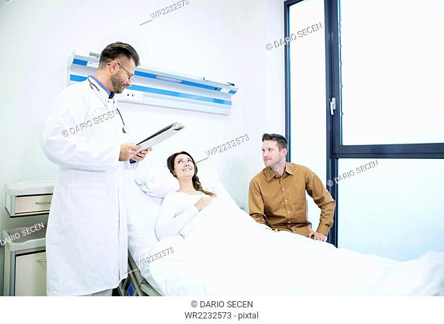 Doctor with patient in sick room of hospital