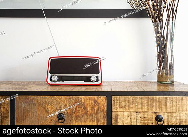 red retro radio player on wooden closet in a living room, modern decoration closeup