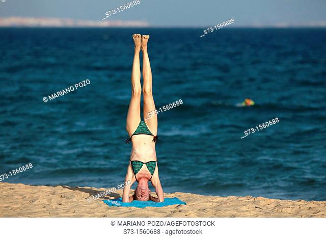 Young woman making yoga in Tarifa beach, Cadiz, Andalusia