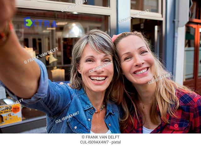 Women taking selfie looking at camera smiling