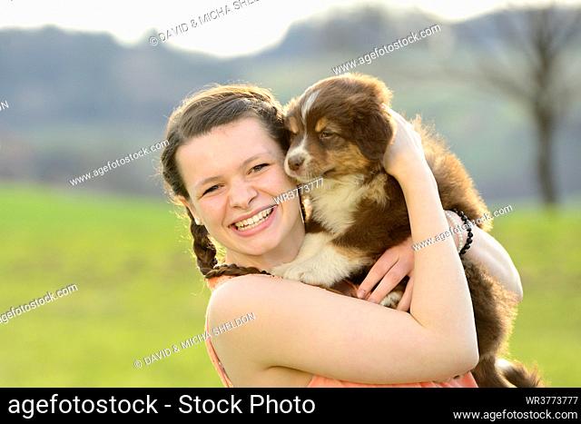 Young woman with australian sheperd puppy, Bavaria, Germany, Europe