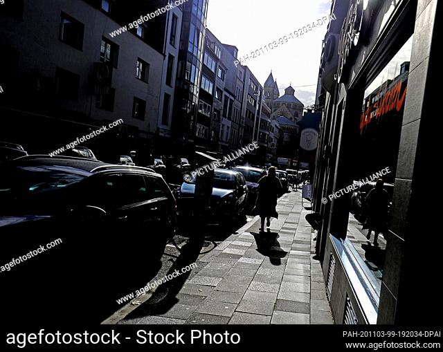 03 November 2020, North Rhine-Westphalia, Cologne: A woman walks through the city in the sun. On November 3, the RKI also reported a further increase in the...