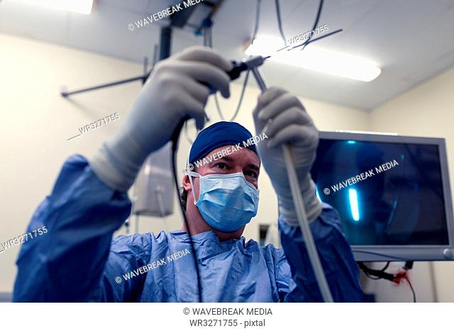 Female surgeon holding medical instrument in operation theatre
