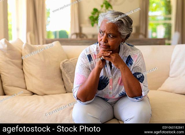 Senior african american woman sitting on sofa and thinking