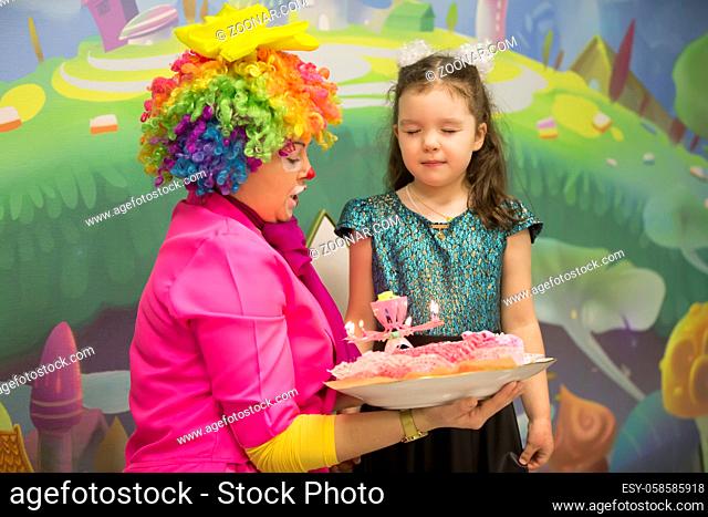 Birthday cake. Make a wish . The clown brought a birthday cake