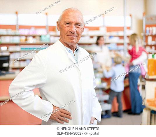 Smiling pharmacist standing in store