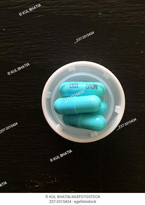 Capsules of Novo 100, a widely prescribed antibiotic, in a white cap