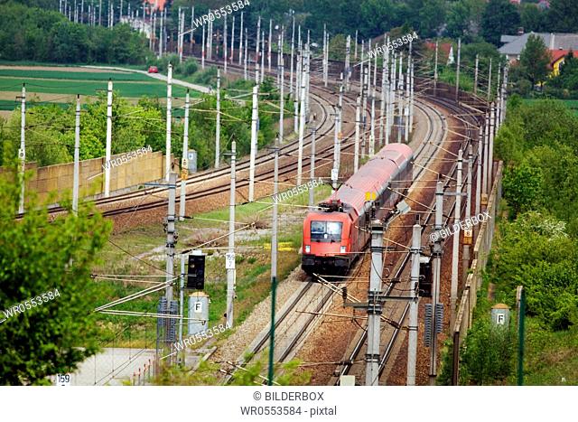 A passsenger train driving on railroad tracks