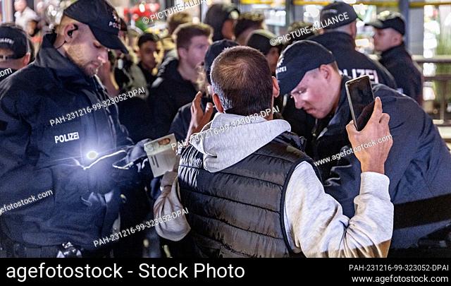 16 December 2023, Hamburg: Police officers search people for weapons and other prohibited items at a checkpoint at Hamburg Central Station
