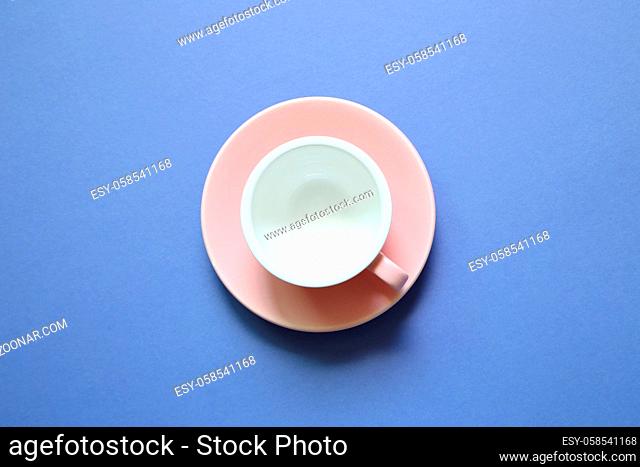 Pink coffee cup on purple background