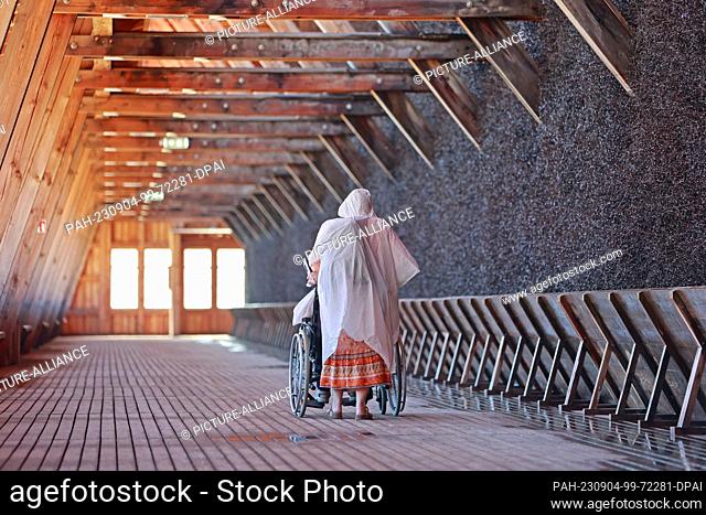 04 September 2023, Thuringia, Bad Salzungen: Visitors walk through the graduation house in Bad Salzungen. Salt water flows down dry branches in the Bad...