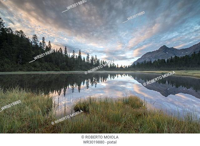 Clouds reflected in Lake Entova at dawn, Entova Alp, Malenco Valley, Sondrio province, Valtellina, Lombardy, Italy, Europe