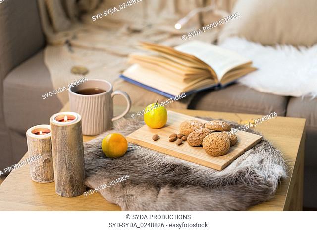 cookies, lemon tea and candles on table at home