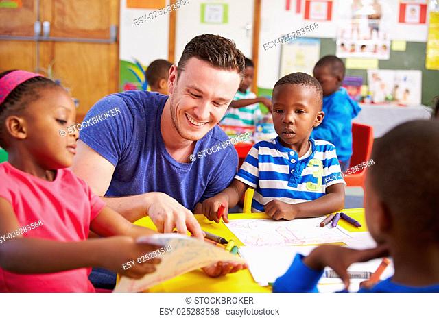 Volunteer teacher sitting with preschool kids in a classroom