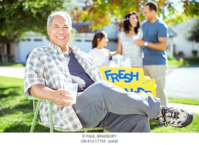 Portrait of smiling man drinking lemonade near lemonade stand