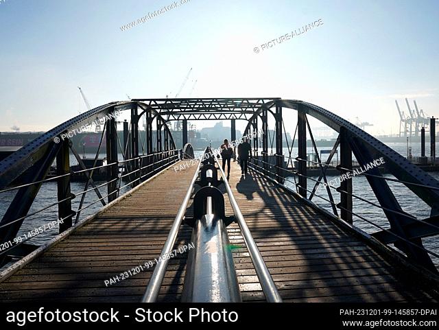 01 December 2023, Hamburg: Passers-by walk to the ferry dock at the fish market. Photo: Marcus Brandt/dpa. - Hamburg/Hamburg/Germany