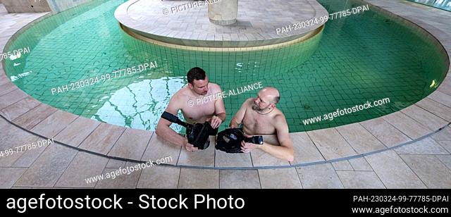 24 March 2023, Saxony-Anhalt, Halle (Saale): Former swimmer and world champion Paul Biedermann (l) has virtual snorkeling explained to him by Bernd Kaltenbach...