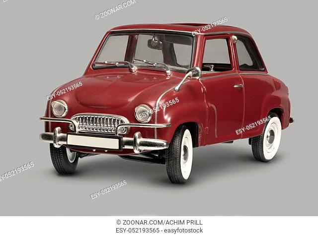 model of a historic red microcar in grey back