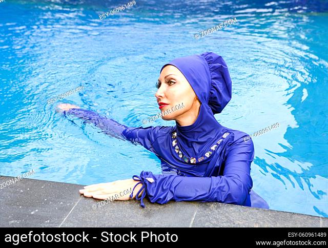 attractive woman in a Muslim swimwear burkini in the pool