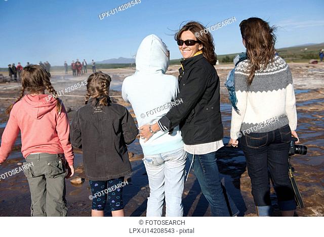 Backside of female family hugging and a turned smiling face