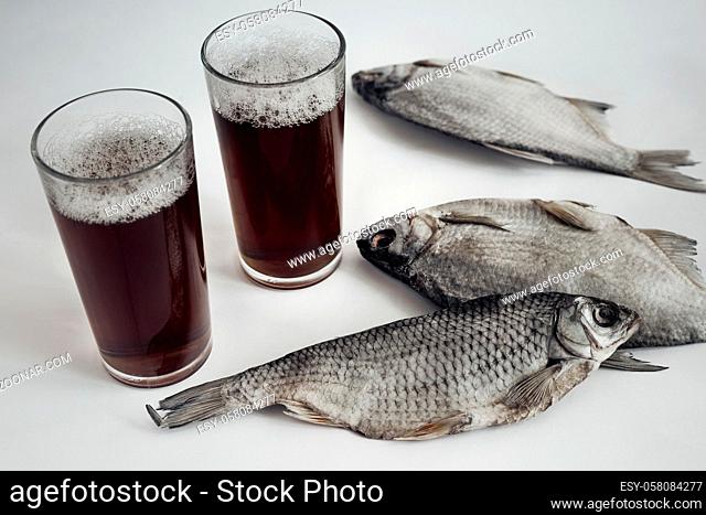 On the bright surface of my Desk is a dried fish, standing next to a glass of beer