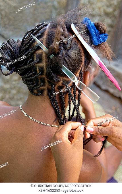 young women braiding hair, Ambatoloaka, Nosy Be island, Republic of Madagascar, Indian Ocean