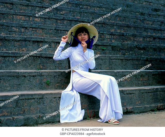 Vietnam: A student in a traditional Vietnamese <i>ao dai</i> ('long dress') and <i>non la</i> (conical hat) at the Thien Mu (Thiên M?) Pagoda, Hue