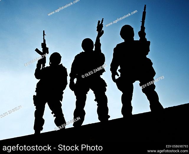 Silhouettes of S. W. A. T. officers holding their guns