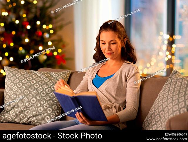 woman reading book at home on christmas