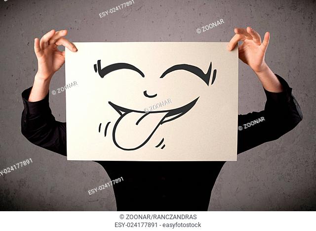 Businessman holding a paper with funny smiley face in front of his head