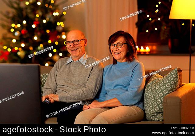 happy senior couple watching tv on christmas